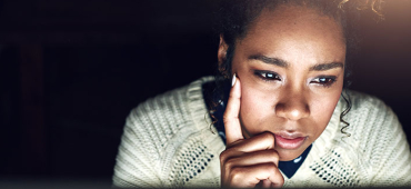 Kvinna framför dator, funderar över behandlingsalternativ